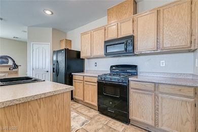 Kitchen featuring black appliances, light brown ca