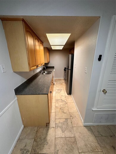 Kitchen featuring dark countertops, fridge, and a