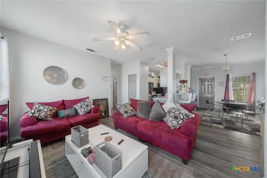 Living room with ceiling fan, ornamental molding,