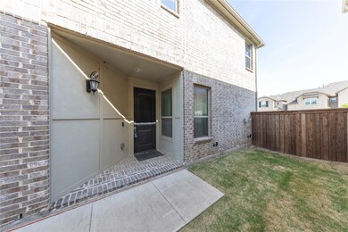 Property entrance featuring brick siding, fence, a