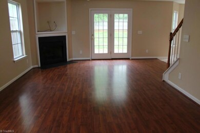 Living Room with Laminate Wood Flooring and Fresh Paint.  Fireplace for comfort! Living Room is open to Dining and Kitchen which is great for entertaining!