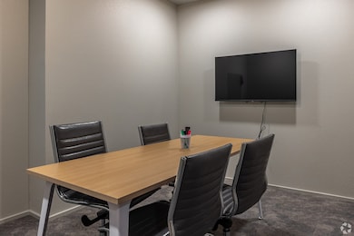 Office area with a textured wall and dark colored carpet