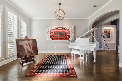 Sitting room with crown molding, dark wood-type flooring, and a chandelier