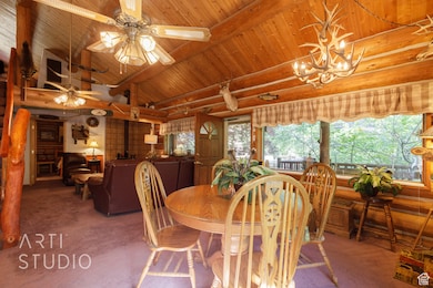 Dining room with carpet, rustic walls, and wood ceiling