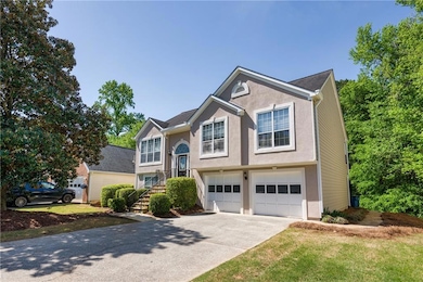 Split foyer home with a garage, driveway, and stuc
