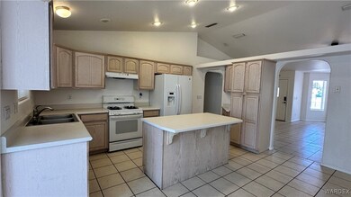 Kitchen featuring light cabinetry, a sink, under c