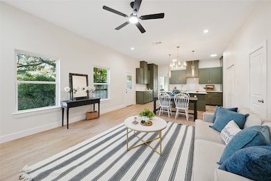 Living area featuring light wood-style flooring, recessed lighting, a chandelier, and ceiling fan