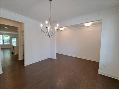 Dining Room with dark wood finished floors, a chandelier, and ornamental molding