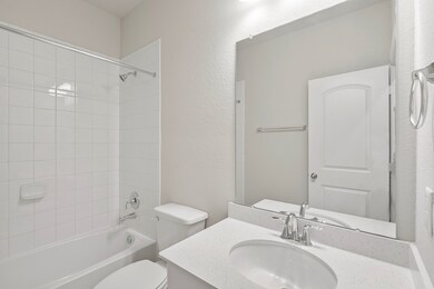 The secondary bath features tile flooring, white c