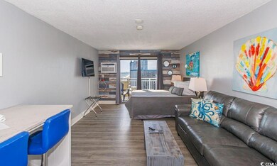 Living room with an AC wall unit, a textured ceili