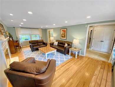 Large living room with hardwood floors, crown mold