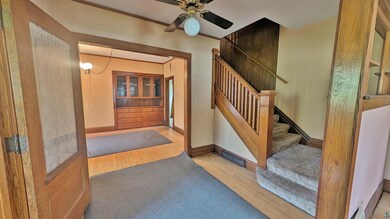 Foyer with ceiling fan and hardwood / wood-style f