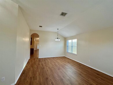 Spare room with wood finished floors, a chandelie