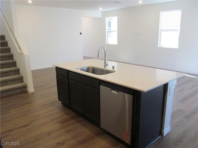 Kitchen featuring light countertops, a sink, stain