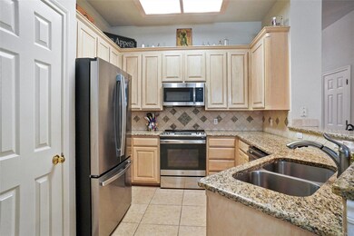 Kitchen with tasteful backsplash, light brown cabi