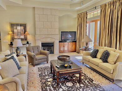 AMAZING GREAT ROOM, COMPLETE W/STONE FIRE-PLACE, SOARING CEILINGS, LOTS OF NATURAL LIGHT, AND STONE FLOORS.