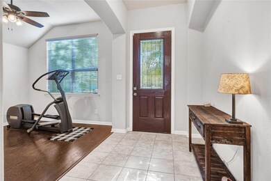 Foyer featuring vaulted ceiling, ceiling fan, and 