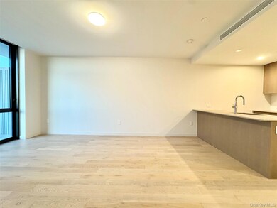 Kitchen featuring light wood-type flooring, a peninsula, floor to ceiling windows, modern cabinets, and light stone countertops