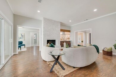 Living room with crown molding, a fireplace, wood 