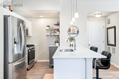 Kitchen with stainless steel appliances, a sink, a peninsula, a breakfast bar, and baseboards