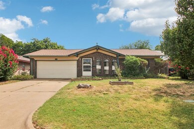 Single story home with a garage and a front yard