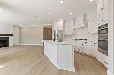 Kitchen featuring a sink, an island with sink, sta
