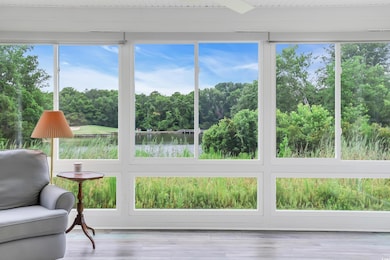 Sunroom / solarium featuring a water view and view of scattered trees