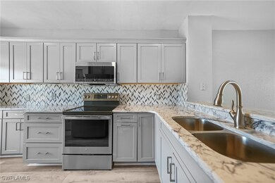 Kitchen with decorative backsplash, light stone co