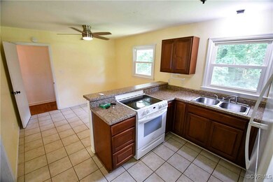 Kitchen featuring white range with electric cookto