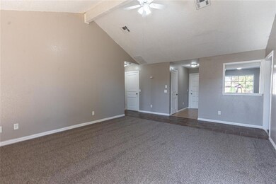 Carpeted spare room with lofted ceiling with beams
