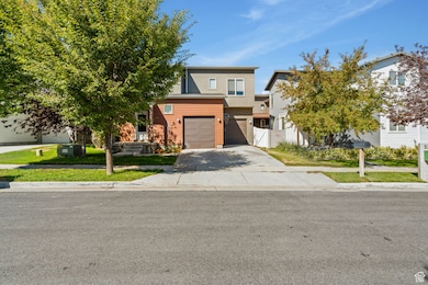 View of front of home featuring driveway, an attached garage, a gate, and stucco siding