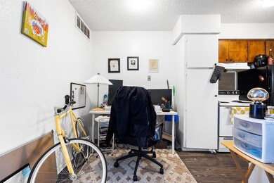 Office featuring a textured ceiling, dark wood-st
