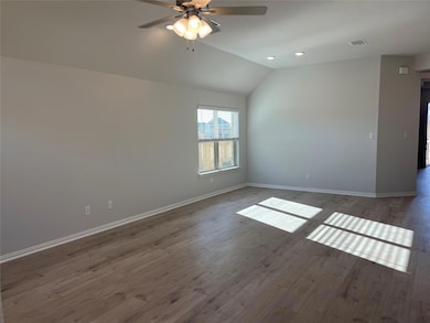 Unfurnished room with dark wood-type flooring, vaulted ceiling, ceiling fan, and recessed lighting