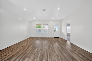 Unfurnished living room with recessed lighting and dark wood-type flooring
