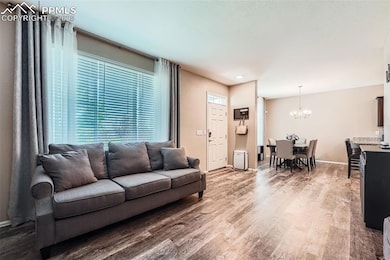 Living room featuring a chandelier, wood finished floors, and plenty of natural light