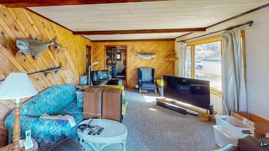 Carpeted living area with beamed ceiling and woode