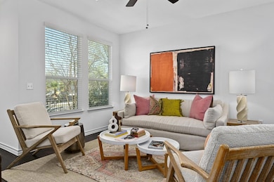 Living room featuring a ceiling fan, baseboards, 