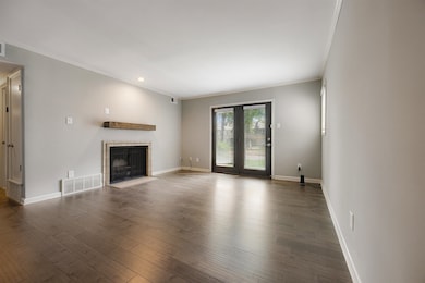 Unfurnished living room featuring crown molding, w