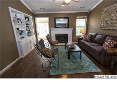 Living room with hardwood floors, painted brick fi