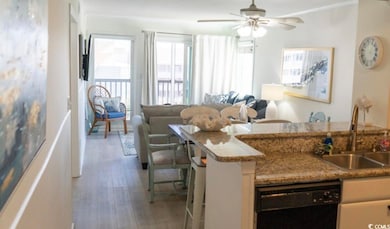 Kitchen with dishwasher, a sink, light wood-style floors, ceiling fan, and open floor plan