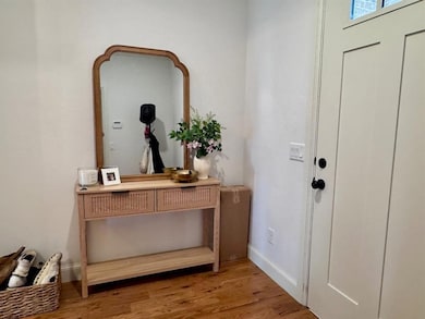 Foyer entrance featuring light wood finished floors and baseboards