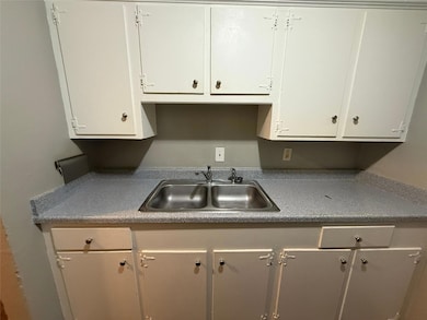 Kitchen featuring dark countertops, white cabinets