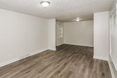 Empty room with a textured ceiling and dark wood-type flooring