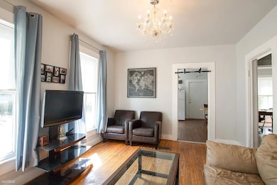Living area with wood finished floors, a chandeli