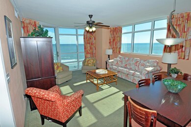 Living room featuring a water view, healthy amount of natural light, ceiling fan, and carpet
