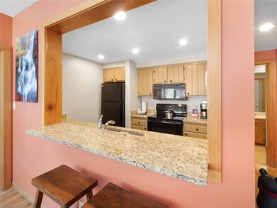Kitchen featuring black appliances, a sink, a peni