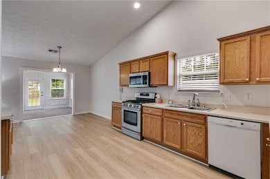 Kitchen with appliances with stainless steel finishes, light wood finished floors, plenty of natural light