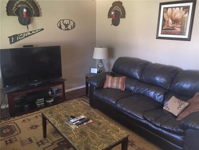 Living area with wood flooring, ceiling fan and ba