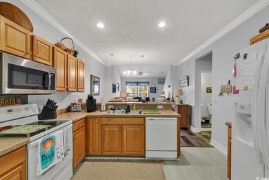 Kitchen featuring a notable chandelier, white appl
