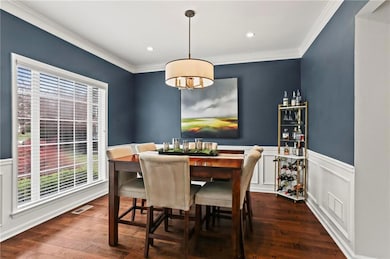 Dining space with crown molding, wainscoting, and 